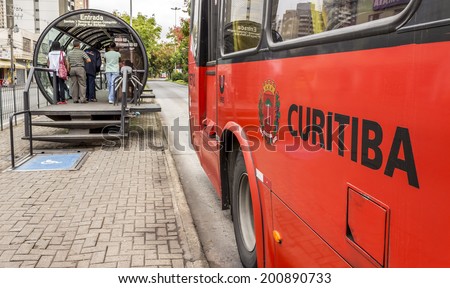 CURITIBA, BRAZIL - MARCH 30: Curitiba's Public Transportation System in PR, Brazil with its tube-shapped bus stops and red buses loading and unloading commuters on March 30, 2014.