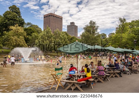 BOSTON, USA - JUNE 10, 2014: Locals and tourists refreshing themselves in a public pool in the Boston Public Garden in Boston, Massachusetts, USA on a very hot summer day of June 10, 2014.