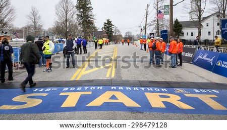 HOPKINTON, USA - APRIL 20: the starting line of the Boston Marathon 2015 with staff members, security personnel, and media people working a few minutes before the start of the race on April 20, 2015.