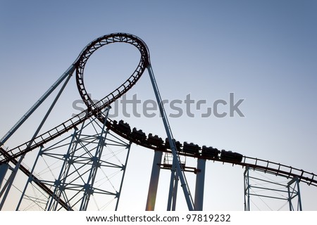 Loop of a roller coaster back lit by the sunset.