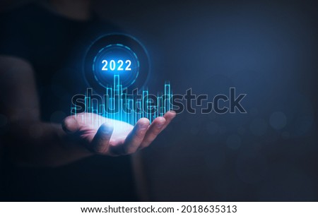 Businessman holding  growth graph a year 2022 of business  and data analysis. Development to success in year 2022. Global financial marketing and growing growth plan. 