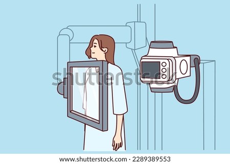 Woman suffering from cancer stands near x-ray machine making medical examination for diagnosing oncological disease. Girl during mammogram for early detection of breast cancer undergoes radiography