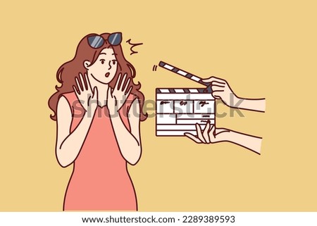 Woman movie star is embarrassed sees clapboard passing casting call for role in popular series or tv show. Movie star girl waving hands, not wanting to film or answer questions from reporters 