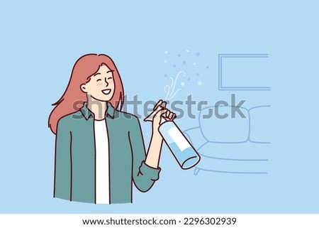 Woman uses air freshener to get rid of unpleasant smell in apartment after cleaning. Housewife girl stands in living room with air freshener spraying fragrance to create comfortable environment