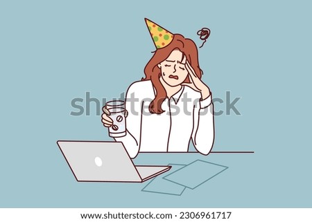 Woman office worker suffers from hangover after party and drinks pills to relieve headache. Girl in birthday hat and business clothes sits at table with laptop experiencing hangover in workplace