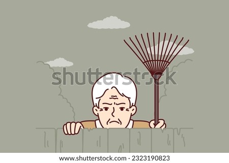 Elderly envious man neighbor peeps from behind fence spying on residents of private house. Envious male pensioner with rake looking at screen suspiciously for bad neighborhood concept.