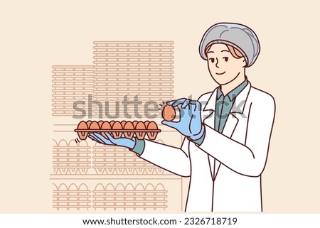 Woman factory worker holds chicken eggs while checking finished product for compliance with quality standards. Young girl factory technologist in white coat works in food industry.