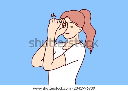 Woman looks through invisible spyglass with curiosity and wanting to know what is happening in distance. Inquisitive girl feels curiosity and puts hands to eyes watching world around her.