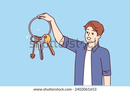 Man holds bunch of keys from entrance to house and garage or safe and smiles, feeling safety thanks presence of reliable locks. Owner of property shows off keys to doors to apartment