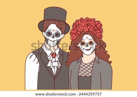 Creepy couple dressed up to celebrate halloween and create scary atmosphere at night party. Young man and woman with painted faces to participate in masquerade on eve of halloween