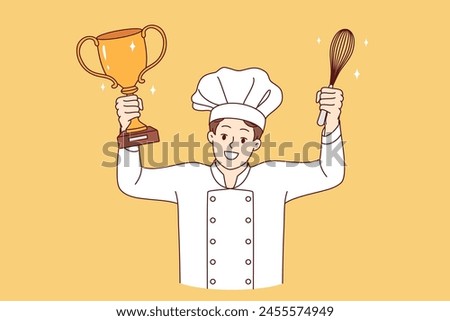 Man chef cook celebrates victory in professional culinary tournament, holds golden cup and whisk in hands. Restaurant chef in white uniform and hat won speed-cooking delicacy competition