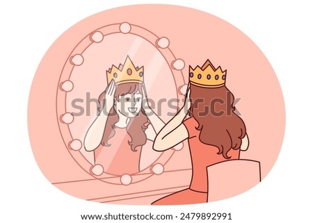 Little actress tries on crown sitting in dressing room with mirror and dreams of playing role of princess on theater stage. Teenage girl puts princess crown on head dreaming of living among kings