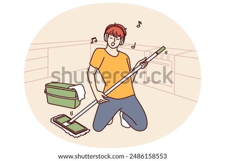 Man cleaning floor with mop stands in pose of rock musician imagining that is holding guitar and performing at concert. Guy in headphones does cleaning dreaming of performing at music rock festival