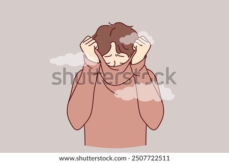 Depressed man hides face behind collar of sweater, feeling shame of actions. Upset guy covers head with shame, trying to hide from others and public censure, causing stress and depression