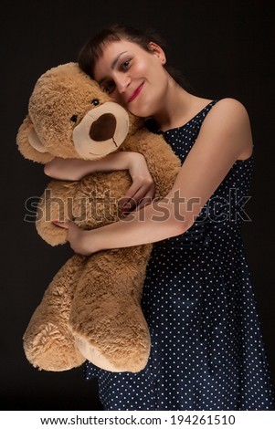 portrait of a stylish expressive woman with teddy bear in studio