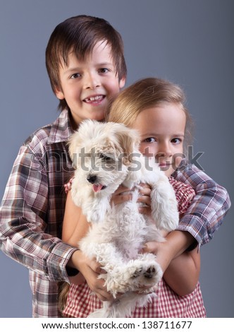 Happy kids holding their new pet - a small fluffy dog