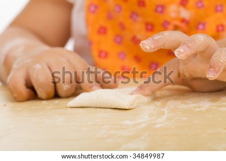 Little girl making cookies series - closing the edges around the filling, closeup