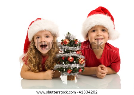 Surprised kids with small decorated tree at christmas time - isolated
