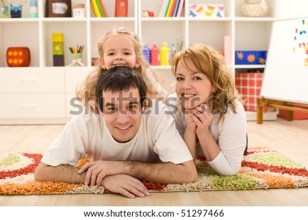 Happy family laying on the floor in the kids room - focus on the little girl