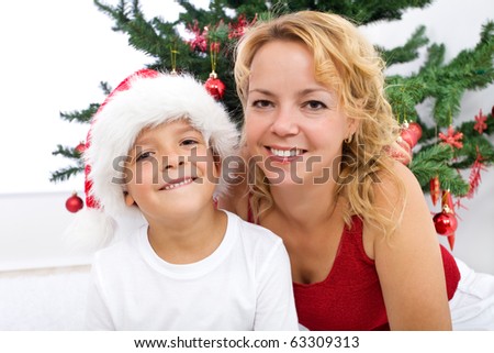 Happy woman and little boy christmas portrait by the decorated tree - high key