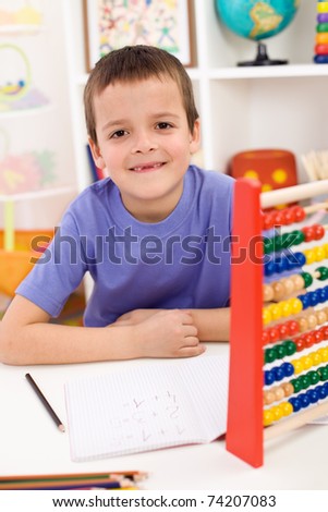 Happy boy solving math exercises in his room