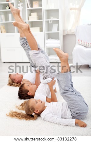 Woman and kids doing gymnastic exercises at home - closeup, focus on the first kid