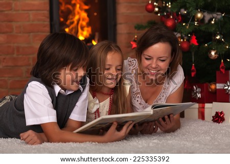 Family reading stories at Christmas time - laying by the fire
