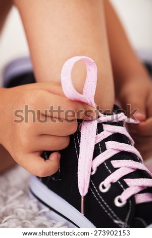 Closeup on child hands as they tie shoes