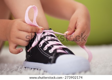 Young girl hands tie shoe laces - closeup