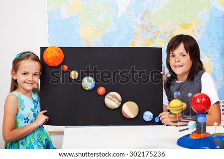 Kids in elementary school science class study the solar system - making a scale model of the planets
