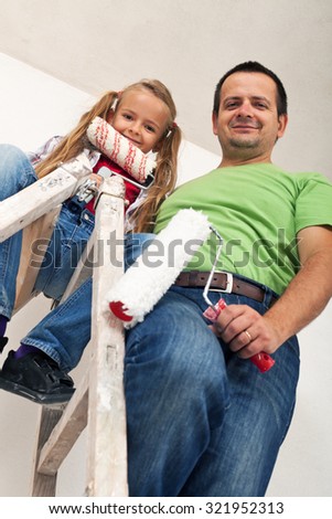 Happy room painters on a ladder - father and little girl smiling