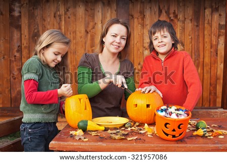 Family carving pumpkin lanterns for halloween - preparing the spooky accessories
