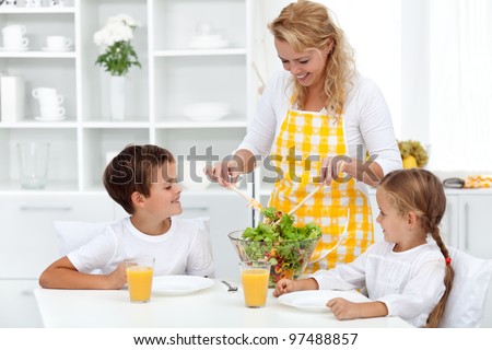 Healthy breakfast for happy life - mother serving kids with salad