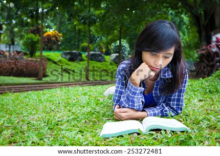 Asian girl reading book and study in the park