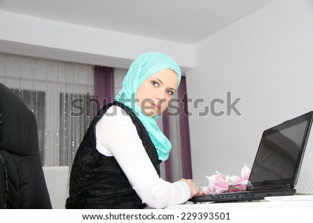 Beautiful young muslim business woman with laptop in office