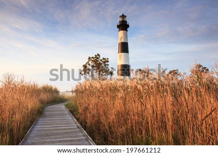 Wooden boardwalk leading through the marsh to the Bodie Island Lighthouse on the Cape Hatteras National Seashore on the Outer Banks in North Carolina.
