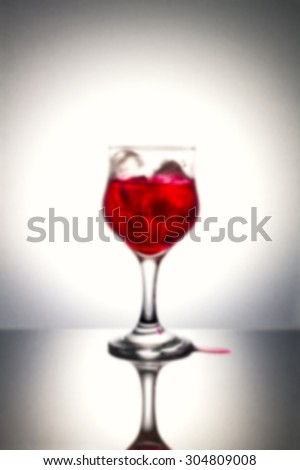 Blurred of red syrup on ice with gray background.Used color tool for color tone and blurry tool.
