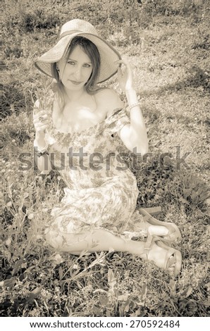 Country girl relaxing on flowering field. Photo taken by low key.
