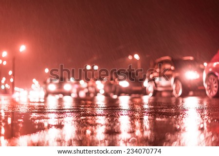 Rainy day in the city at night, stream of cars on the road