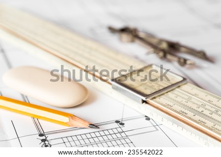 Preparation for drafting papers, the tools and schemes on the table. Angle view, focus on a slide rule