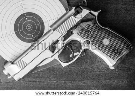 Target shooting, the gun and the target on the table. Top view