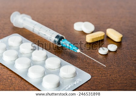 Cure the disease, an injection syringe and take the pills and vitamins. Angle view