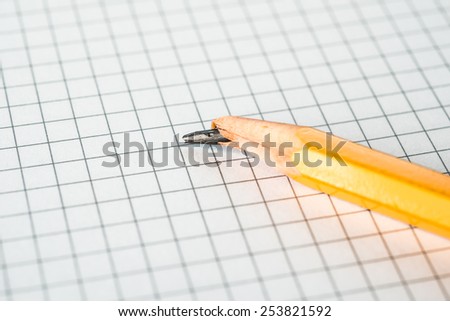 Broken pencil lying on a notepad