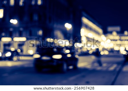 Nights lights of the big city, cars at night with pedestrian on the avenue. Image in blue toning