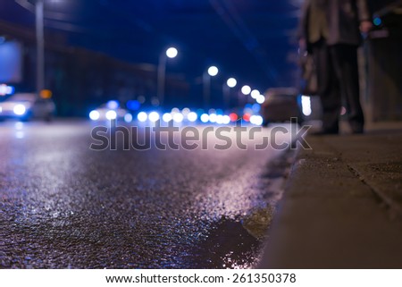 Nightlife, people waiting for a transport to a traffic stop. In blue tones