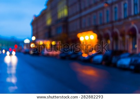 The bright lights of the evening city, the street going car. Defocused image in blue tones