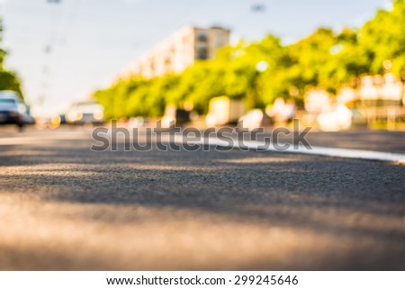 Sunny day in a city, view of the light from the headlights of approaching cars to the road level