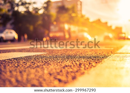 Sunny day in a city, smog on a city street, the view from the level of asphalt. Image in the orange-purple toning
