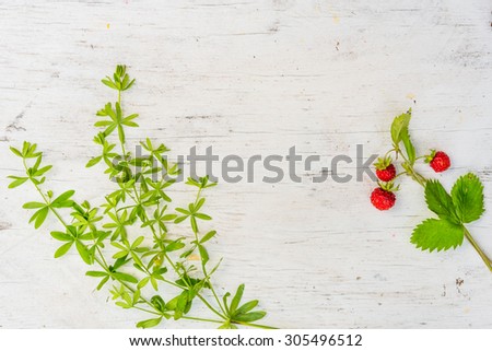 Strawberry with grass on old wooden table