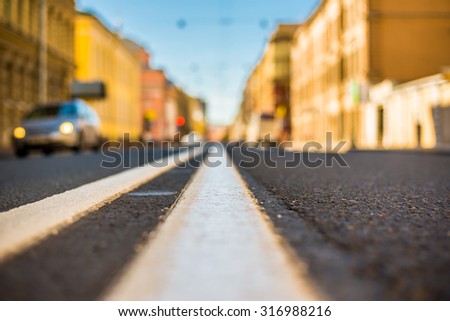 Clear day in the big city, car traveling on an empty city street. View of the road at the level of the dividing line